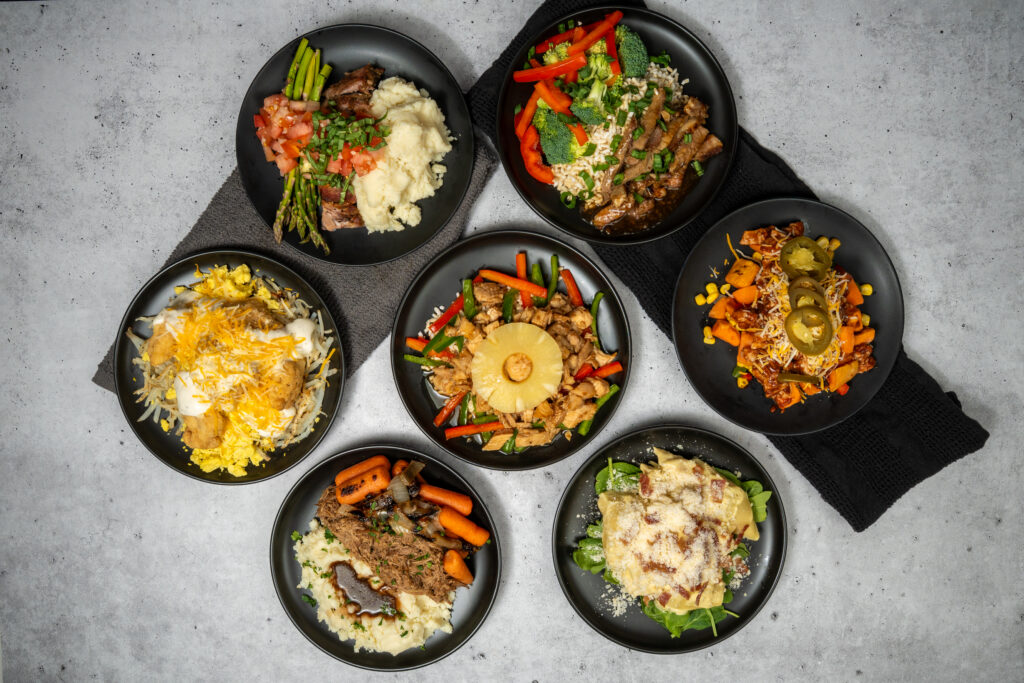 Clean Eatz meal prep containers with healthy prepared meals arranged for weekly meal planning