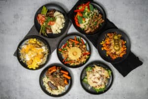 Clean Eatz meal prep containers with healthy prepared meals arranged for weekly meal planning